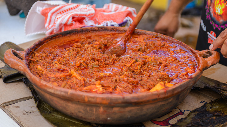 birria cooking in a large clay pot with handles