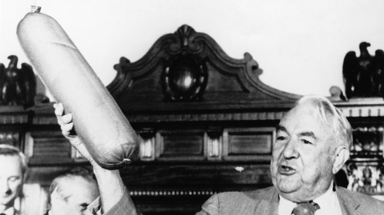 Chairman Ervin holds up a huge bologna as the last piece of evidence in the Watergate investigation