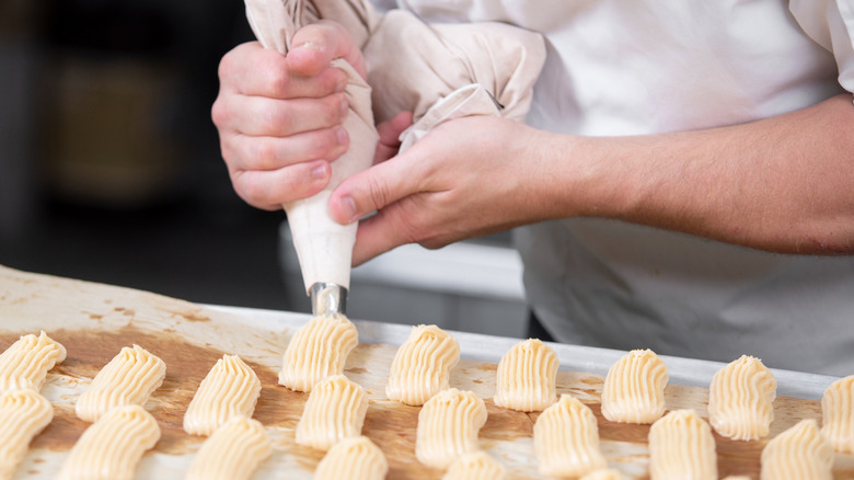 Pastry chef piping pastries