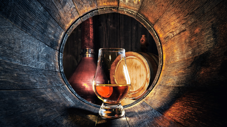 Bourbon glass inside whiskey barrel