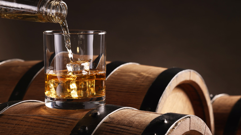 Bourbon glass on whiskey barrel