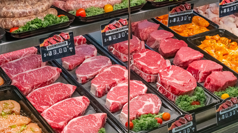 Variety of raw meat cuts in a butcher case