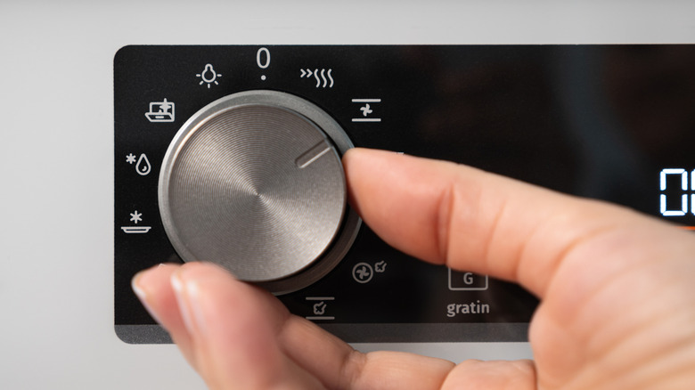 Person turning an oven knob