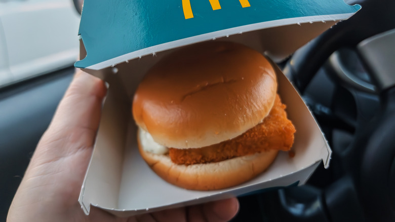 Hand holding carton with Filet-O-Fish in car