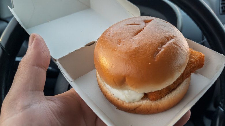 Hand holding carton with Filet-O-Fish in car