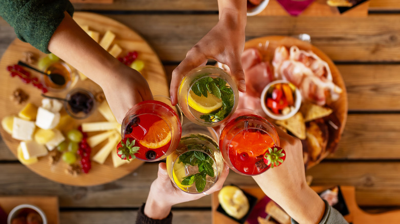 Friends share cocktails over table