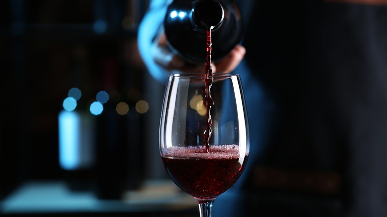 pouring red wine into glass