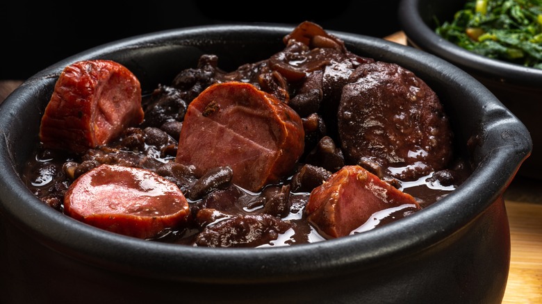 Bowl of feijoada with black beans and sliced sausage