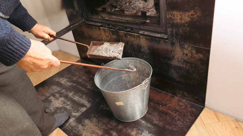 Person removing wood ash from their home fireplace