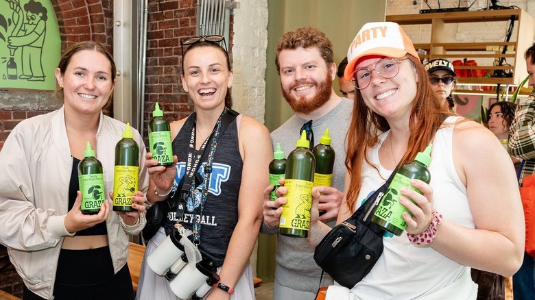 Various influencers holding bottles of Graza olive oil.