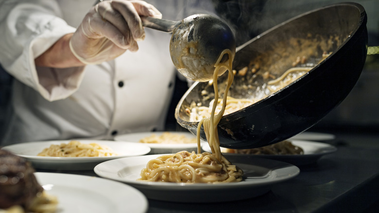 Chef Serving Pasta On Plates