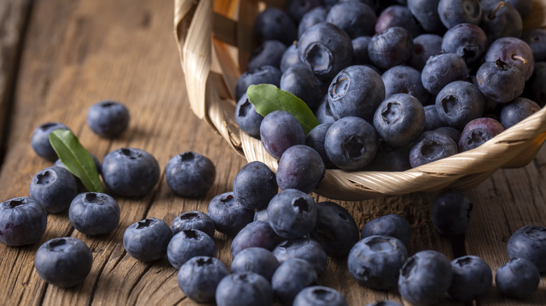 Blueberries falling out of a basket