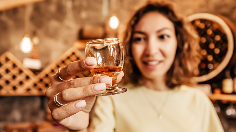 woman holding glass of whiskey