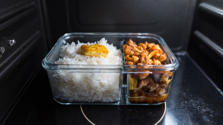 Rice and meat and vegetables in a glass container in a microwave