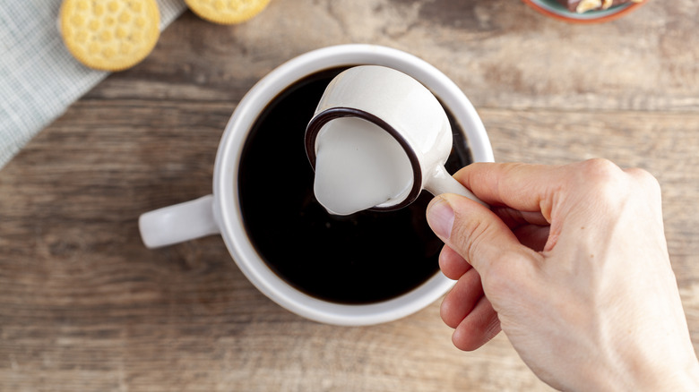 creamer being poured into coffee 