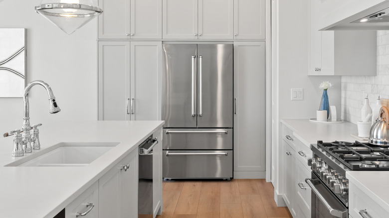 A modern silver two-door refrigerator in a minimalist kitchen