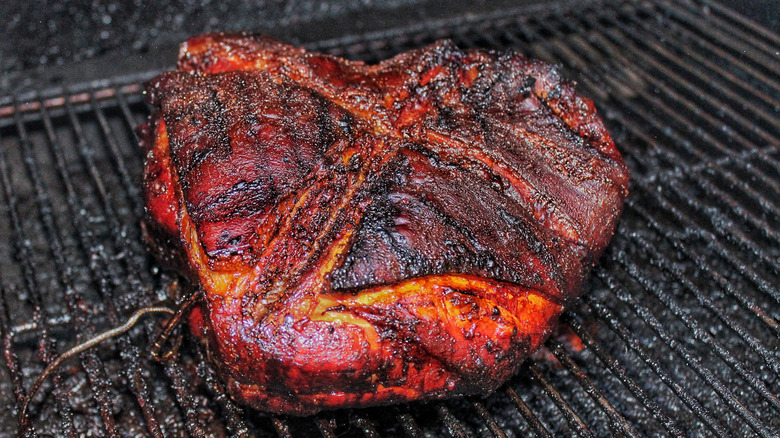 smoked pork butt on a grill