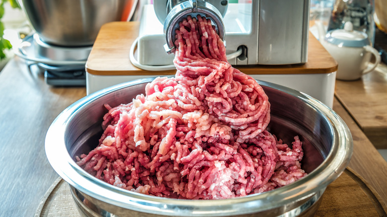 Grinding ground beef into a bowl