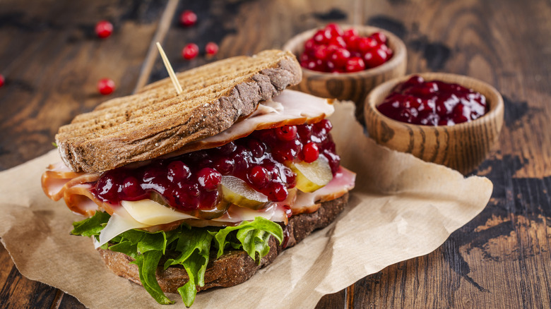 turkey, swiss cheese, pickle, lettuce, and cranberry sauce sandwich