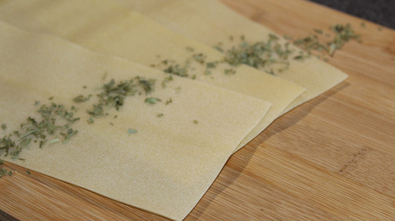 herbs sprinkled over fresh pasta sheets