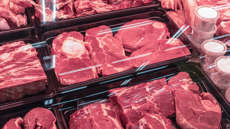 A selection of beef in different cuts, packaged in clear plastic lid black containers.