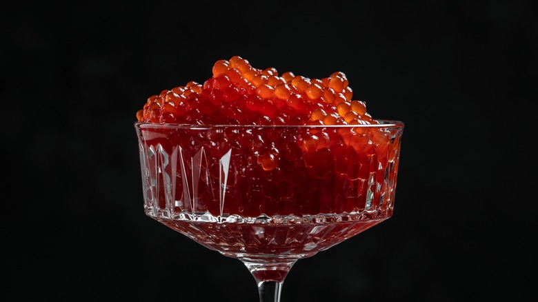 A cocktail glass filled with salmon caviar