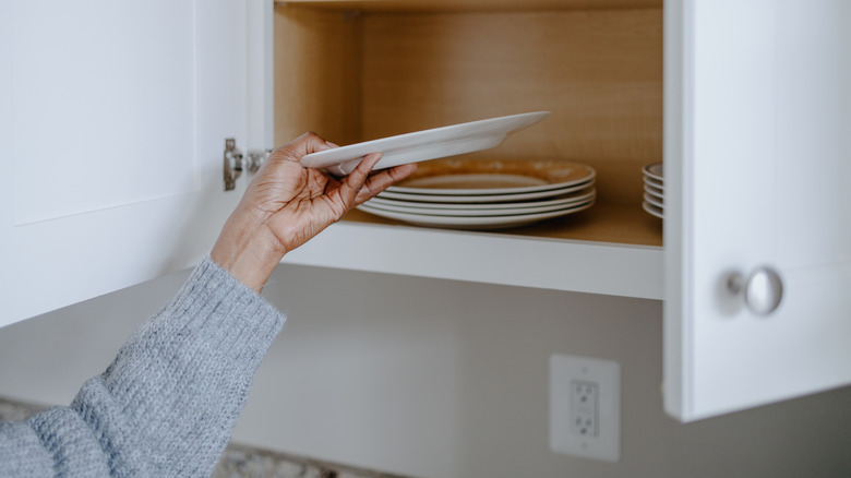 Foodie grabbing a plate from a cabinet