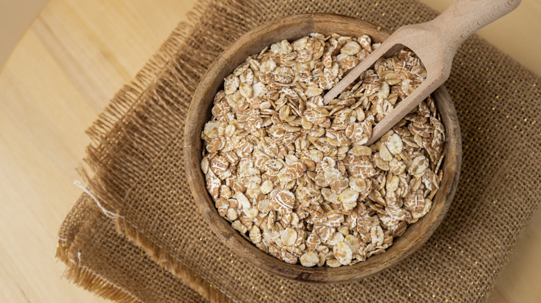 Raw oatmeal porridge wooden bowl