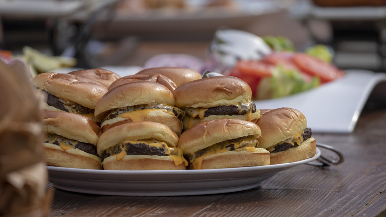 Tray of homemade cheeseburgers at a cookout
