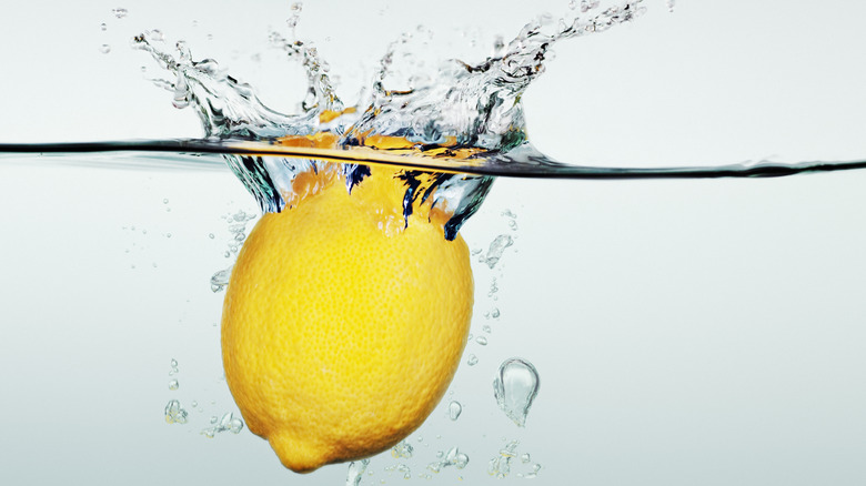 one lemon splashing into water