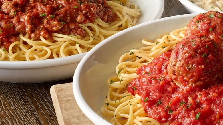 Bowls of Olive Garden spaghetti and meatball pasta on a table.