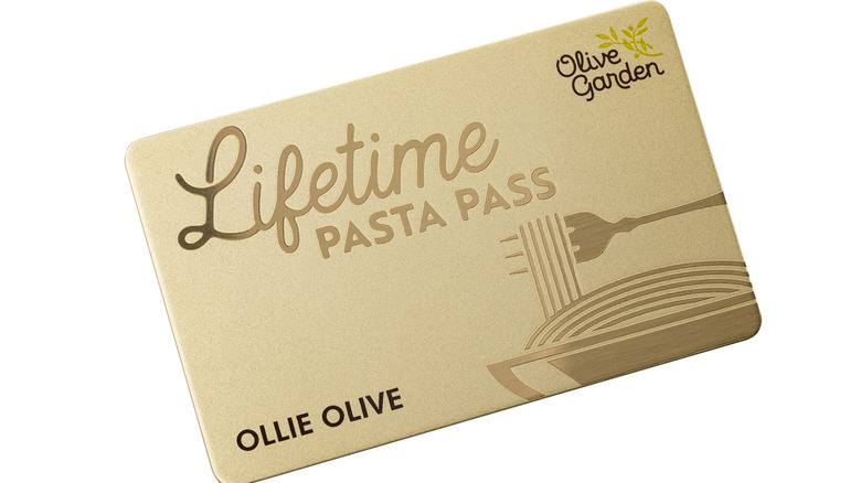 A gold Olive Garden Lifetime Pasta Pass on a white background.