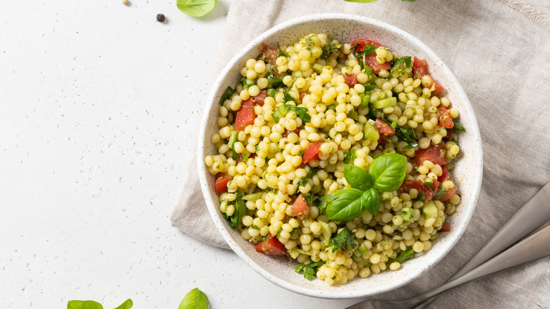 bowl of couscous with sprig of basil