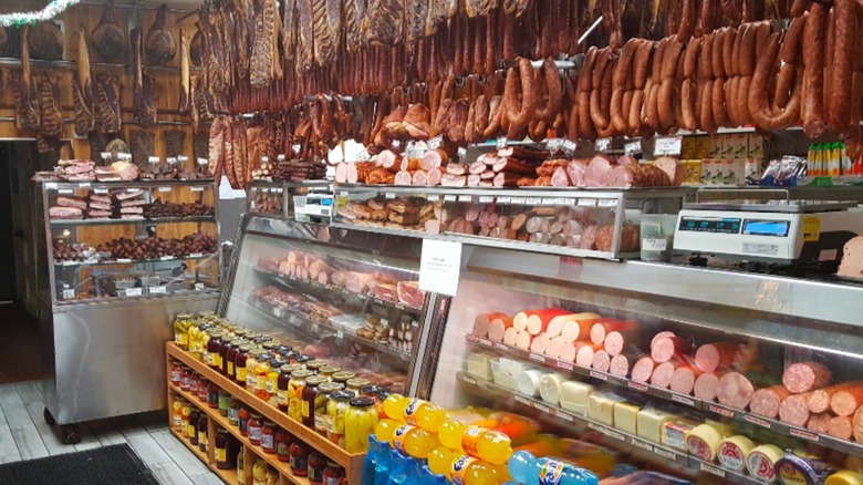 The inside of Muncan, a wood-paneled butcher shop packed with hanging smoked meats