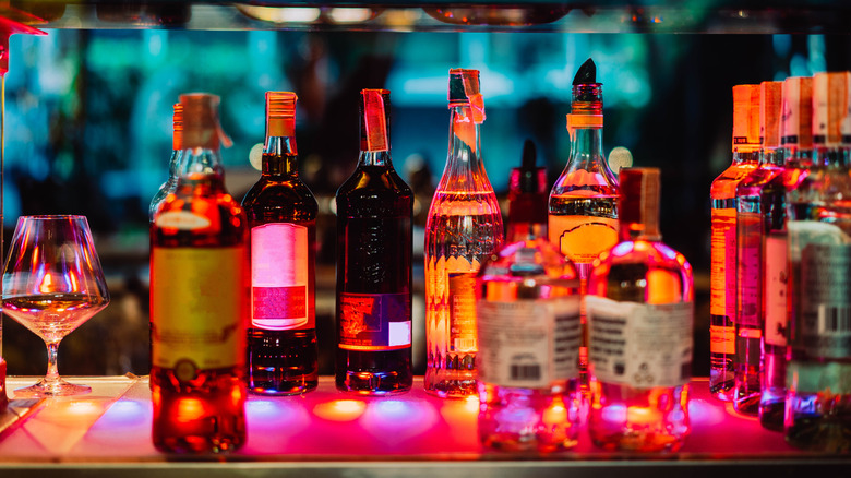 Several rows of liquor bottles and glasses behind a bar