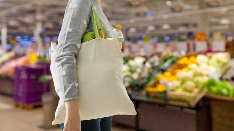 person carrying reusable shopping bag