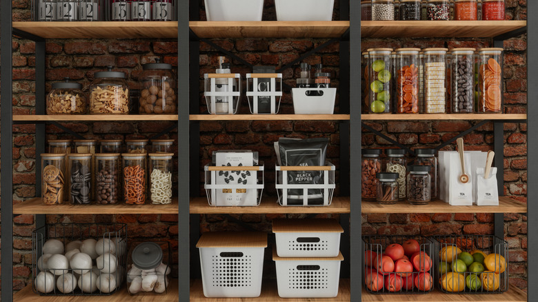 Neatly organized pantry with jars and containers on the shelves and baskets filled with produce