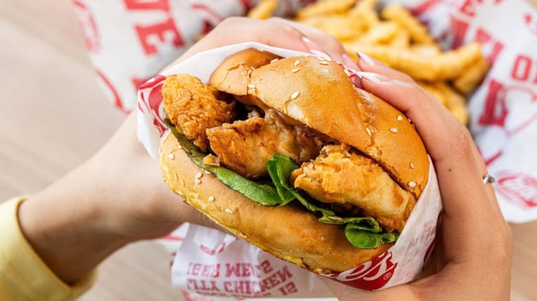 Hands holding a Raising Cane's fried chicken sandwich