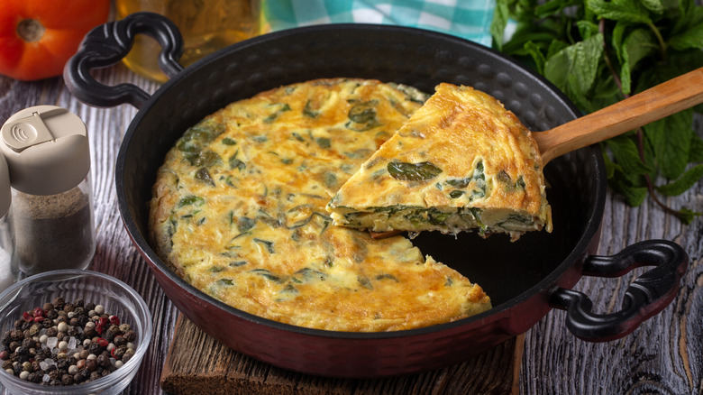 Person serving a vegetable frittata