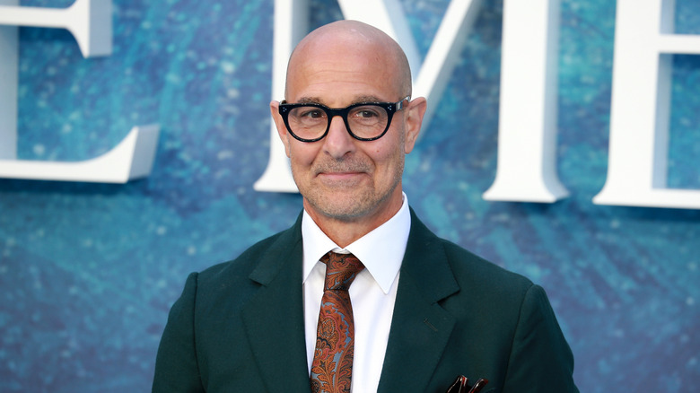 Stanley Tucci headshot on blue background