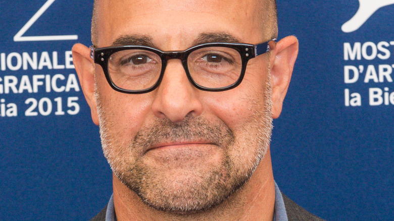 stanley tucci smiles with glasses in close-up