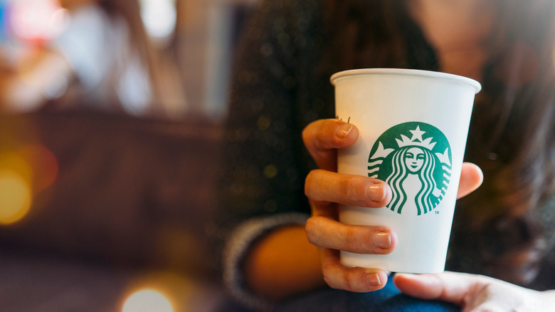 woman holding starbucks cup