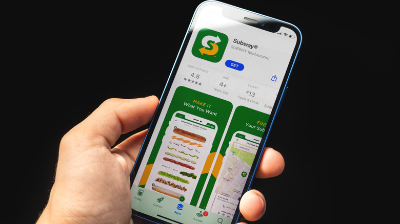 hand holding photo showing Subway app