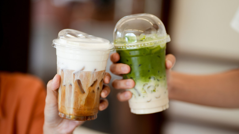 People holding iced coffee and matcha drinks together