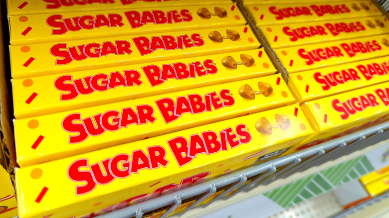 Yellow and red Sugar Babies boxes on a shelf.