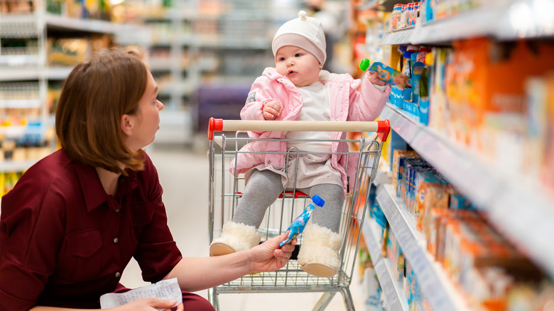woman, baby in supermarket baby-food aisle
