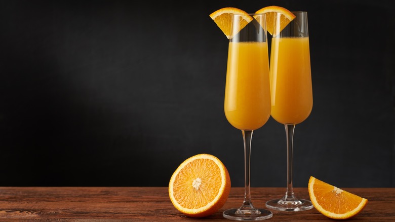 two mimosa cocktails with oranges