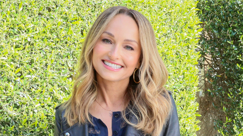 Giada De Laurentiis headshot with leafy green hedgerow in background