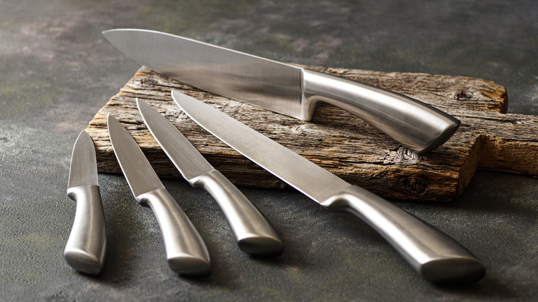 selection of steel knives on wooden block