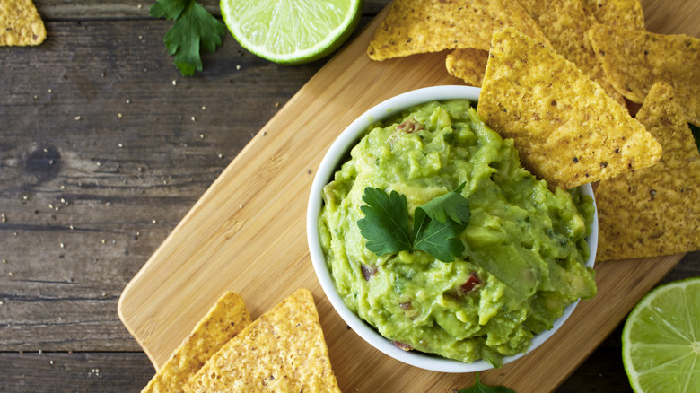 tortilla chips around a bowl of guacamole